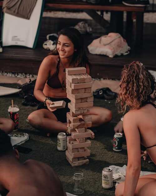 fete jucând jenga si zâmbind