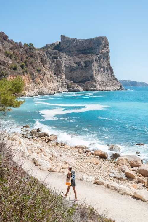 bărbat pe plajă cupietre și stânci aproape