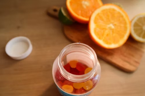 portocale tăiate si un recipient cu suplimente gumate