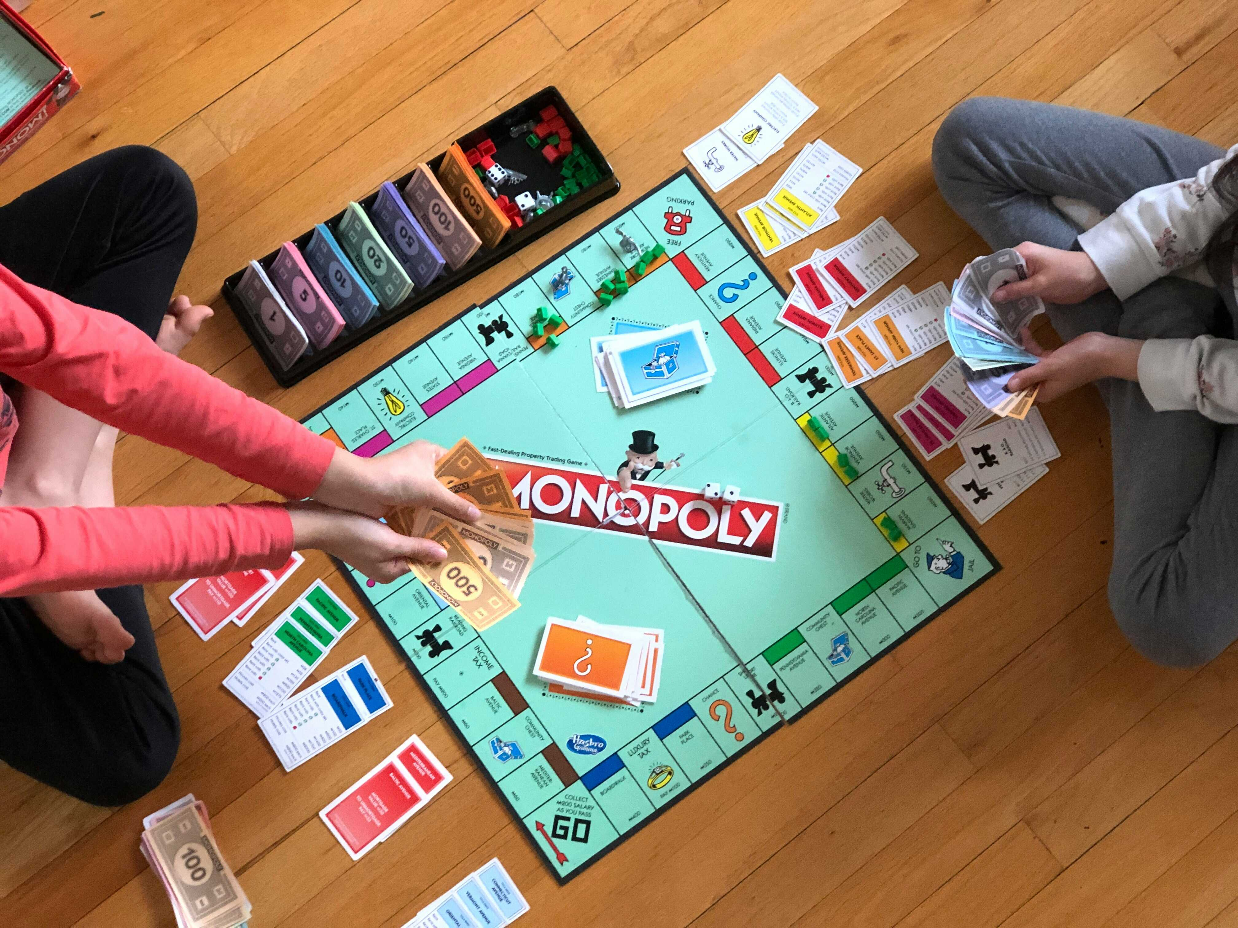 fete jucând monopoly pe jos