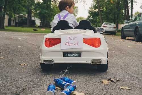 mașinuță de copii alba cu doze albastre după ea