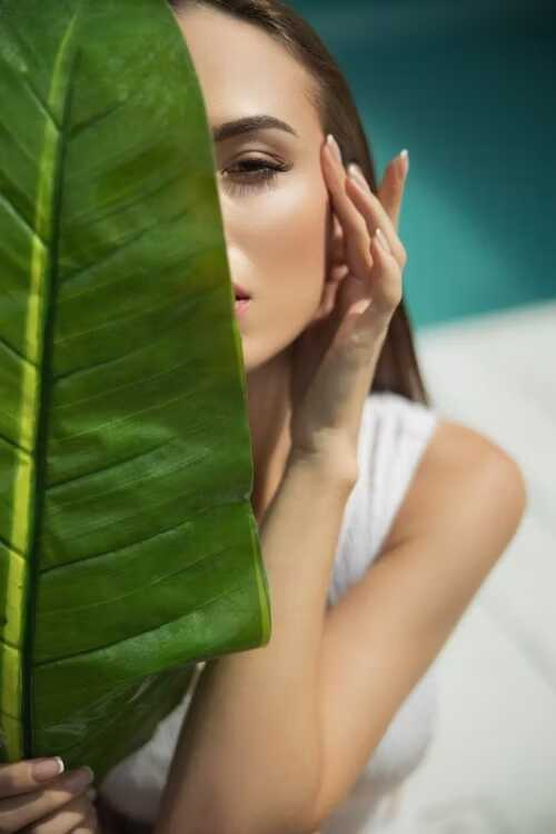femeia ascunsa după o frunza mare verde
