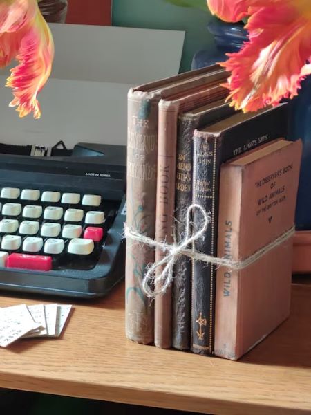 cărți vechi legate cu sfoară lângă o mașină veche de scris